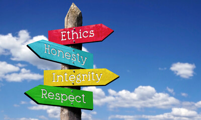 Ethics, honesty, integrity, respect - wooden signpost with four arrows, sky with clouds © PX Media