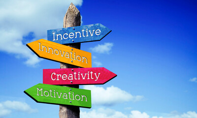 Creativity, innovation, incentive, motivation - wooden signpost with four arrows, sky with clouds © PX Media