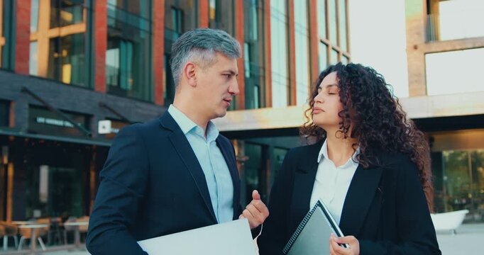 Professional Business Colleagues man and woman standing and Talking Outside Modern Office Building