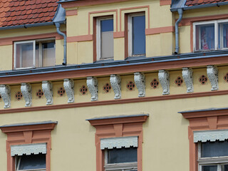 Cornice with decorative stucco brackets and sculpted leaf ornaments. Repeating quatrefoil motifs form an ornamental architectural frieze. © Frank