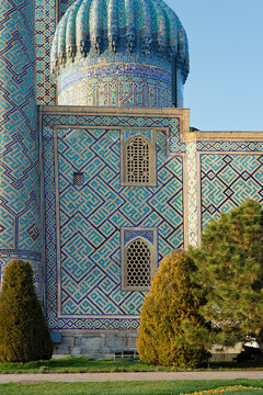 Sher-Dor Madrasah facade detail at Registan Square in Samarkand showing intricate geometric tilework and ribbed dome. Ideal for travel guides, cultural publications, and architectural references.