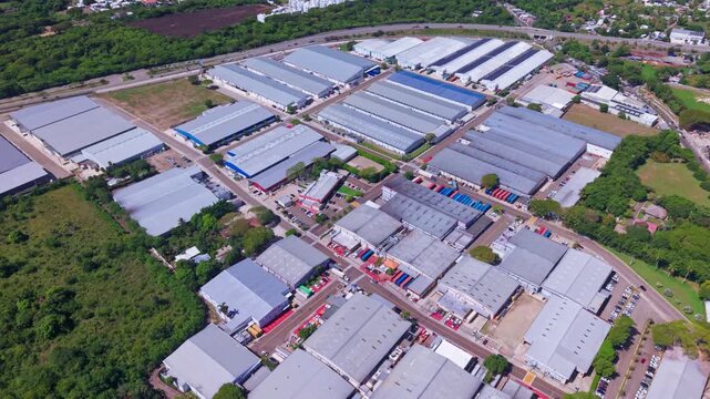 An overhead drone shot capturing a modern industrial park with large warehouses, distribution centers, and connecting roads in Tamboril, Santiago