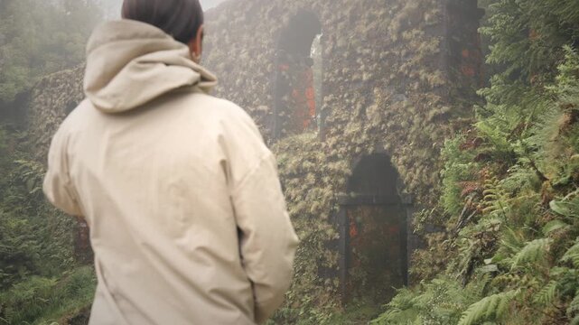 Woman passing by Azores aqueduct ruins