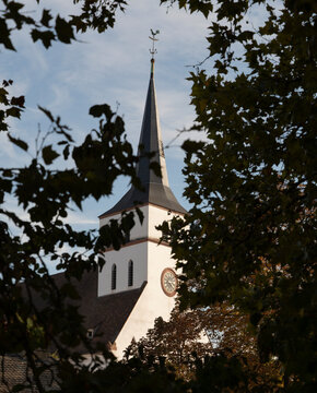 Spire of Saint William's Church framed by autumn foliage in Strasbourg