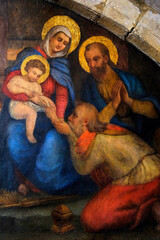 Saint Eucaire Church, Metz, Moselle, France. Detail of a mural depicting the Epiphany. One of the Magi kneels to kiss the hand of the seated Baby Jesus. © Julian