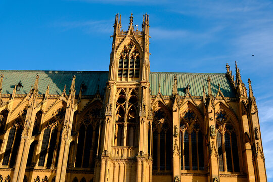 Saint-Etienne Cathedral, Metz, Moselle, France. View of the Gothic side facade made of golden stone, featuring its openwork tower, pinnacles, flying buttresses, and large windows.