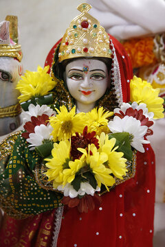 Marble statue of the goddess Parvati adorned with a red sari and flowers at the Shree Hindu Temple in Leicester, United Kingdom