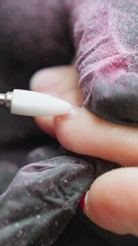 Close up view of foot during pedicure with gloved hand using electric drill to remove calluses care nail technician toenail trimming callus removal file