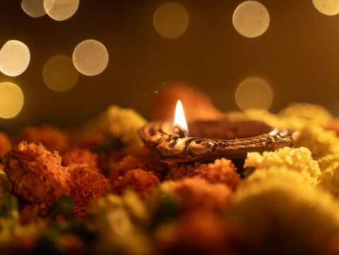 Traditional Clay Diya with a Lit Flame Against a Dreamy Warm Golden Bokeh Background, Festive Diwali Close-Up Shot
