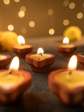Traditional Clay Diya with a Lit Flame Against a Dreamy Warm Golden Bokeh Background, Festive Diwali Close-Up Shot
