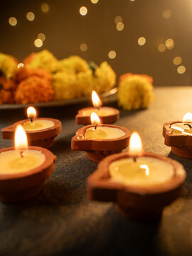 Traditional Clay Diya with a Lit Flame Against a Dreamy Warm Golden Bokeh Background, Festive Diwali Close-Up Shot

