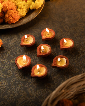 Traditional Clay Diya with a Lit Flame Against a Dreamy Warm Golden Bokeh Background, Festive Diwali Close-Up Shot

