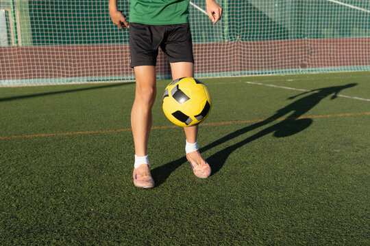 Young boy juggling soccer ball training on field