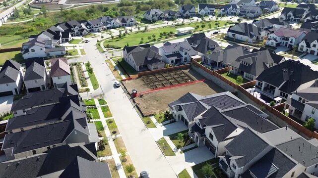 Adjacent construction sites show marked ground footprints bordered by newly built brick estates along Frisco. Roadways wind through developing suburban sectors featuring modern, Texas