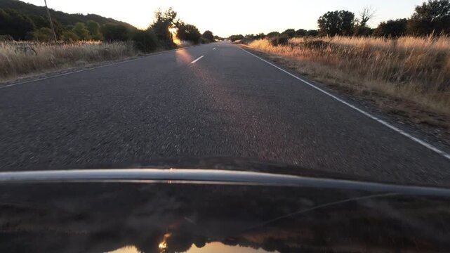Driving Into Blinding Sunset on a Rural Asphalt Road