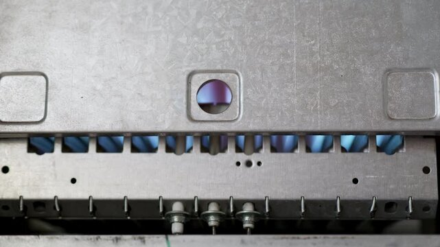 Close up of industrial metal gas pressure control valve with blue internal components and mechanical fittings in a factory equipment setting