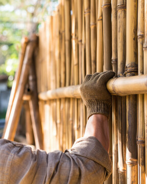 Bamboo construction, craftsman glove, wooden structure, outdoor workshop, bamboo stalk, natural material, craftsmanship