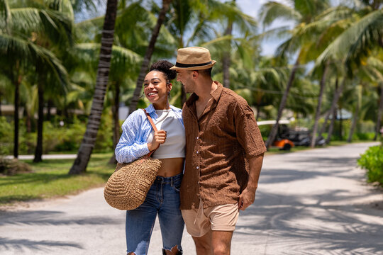 Radiant young couple laughing and enjoying the ultimate tropical holiday experience