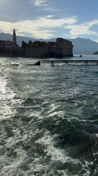 Sea Waves Rolling Onto Pebble Beach by Historic Coastal Old Town