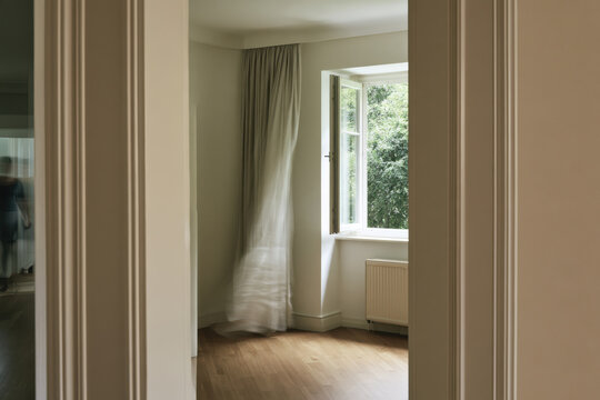 A bright, empty room featuring a window that lets in natural light and offers scenic views of greenery, creating a serene and inviting atmosphere for living or working.