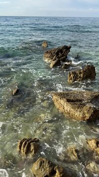 Clear Sea Waves Breaking Over Shallow Coastal Rocks in Slow Motion