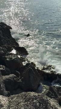 Sea Waves Crashing and Splashing White Foam Over Coastal Rocks