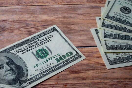 Hundred Dollar Bill and Cash Stack on Wood