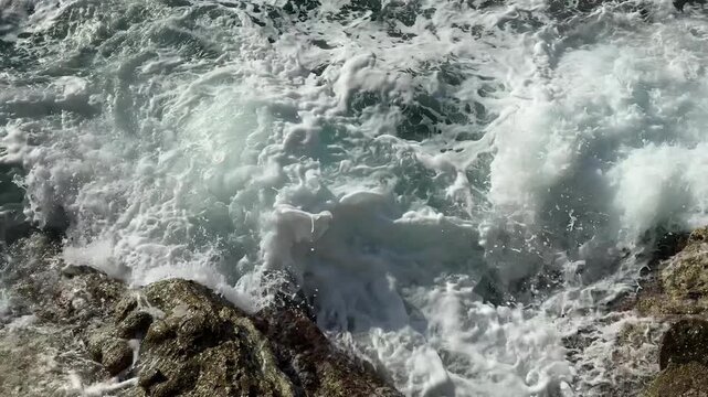 Overhead View of Churning White Surf and Foam on Coastal Rocks
