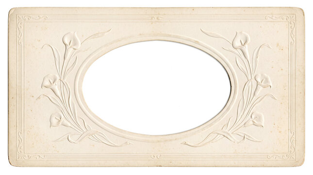 A vintage photograph mount with embossed floral motifs and an empty oval aperture, hinting at a bygone era's photographic display.