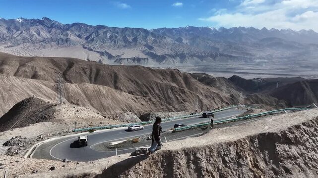 winding panlong ancient road in xinjiang with cars driving on mountain highway