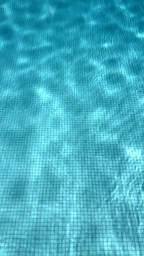 Blue water in the swimming pool with light reflections.