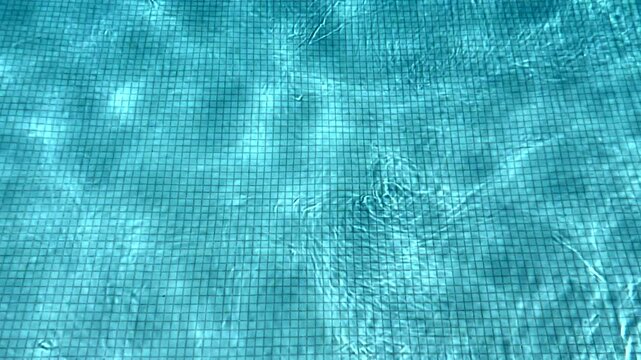 Blue water in the swimming pool with light reflections.