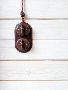 Vintage electric light switch hanging on a white wooden wall with copy space