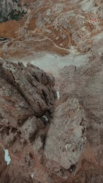 FPV drone flying along the surface of mountain cliffs of Cristallo mountain.
