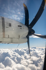 Airplane propeller and engine above a sea of clouds, view from a turboprop window © N. Junker