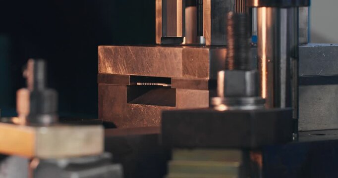 Stamping tooling in operation during metal component blanking. Close-up of working die on industrial mechanical press