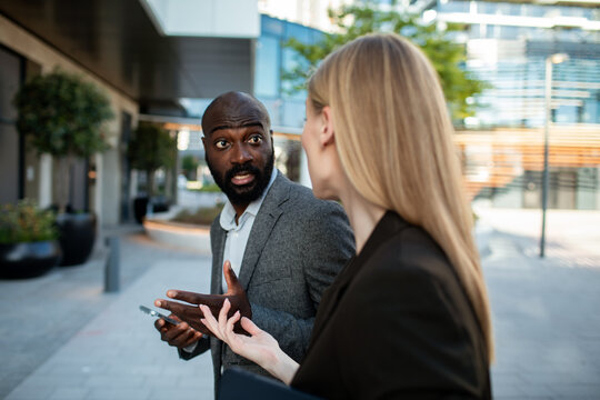 Coworkers in animated discussion while walking outside office