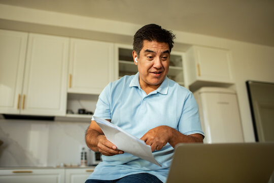 Man discussing paperwork on video call at home