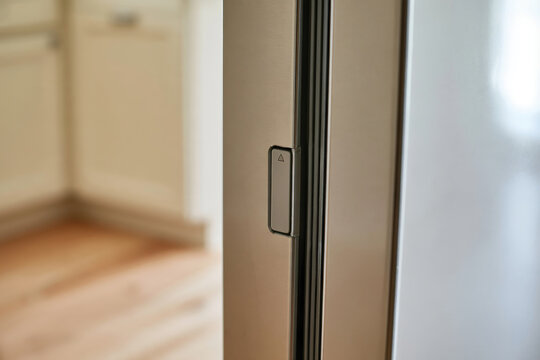 A sleek modern refrigerator door is shown with an emphasis on the handle and its design highlighting the elegance and functionality of contemporary kitchen appliances.