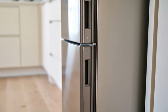 This side view of a refrigerator captures the stylish door handle details, embodying modern kitchen aesthetics and the practical aspects of food preservation.