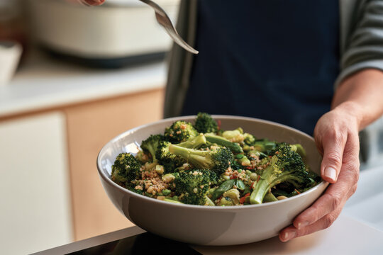 A nutritious bowl brimming with broccoli and assorted green vegetables is elegantly held, reflecting the essence of healthy eating and joyful culinary creativity.