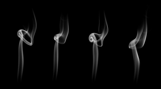 Set of four curly white incense smoke wisps rising gracefully on a black background. Concept of spiritual atmosphere, aromatherapy, mindfulness meditation, and abstract vapor overlay.