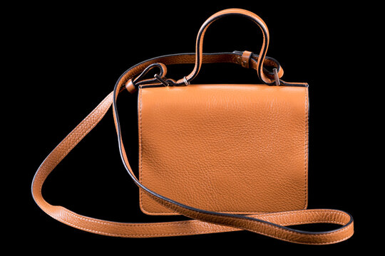 Brown leather womens crossbody handbag with top handle isolated on black background