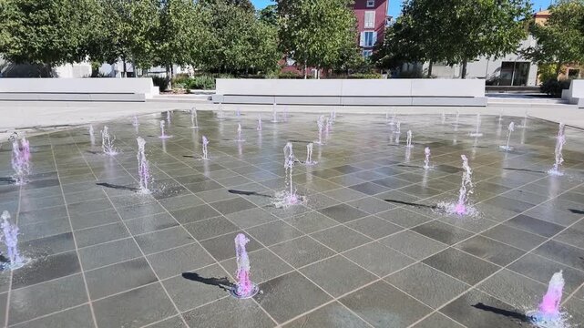 Contemporary ground-level fountain with multiple water jets creates a geometric water feature in an open public square in Koper, Slovenia
