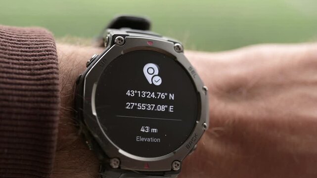 Man checking GPS coordinates and elevation on smartwatch close up