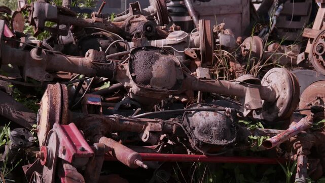 Pile of Rusted Auto Axle Housings Differential Covers and Drum Brakes in Scrapyard