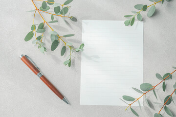 Blank Lined Letter Paper and Wooden Pen with Eucalyptus on Textured Greige Background © 清美 小池