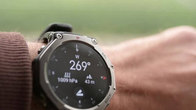 Man checking compass, barometer and elevation on smartwatch close up
