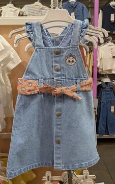 Vestido de tela vaquera con tirantes y botones met&aacute;licos con el estampado bordado de Marie, de The Aristocats de Disney, con un cintur&oacute;n anudado, tienda Kiabi, Madrid, Espa&ntilde;a, 9 de julio de 2026