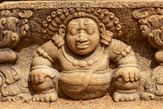 Ancient stone carving of a smiling dwarf figure, North Central Province, Anuradhapura, Sri Lanka